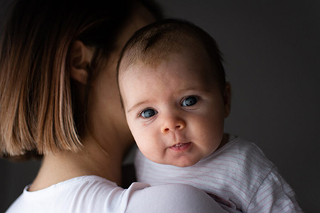 Portrait-Foto von Baby auf der Schulter der Mama